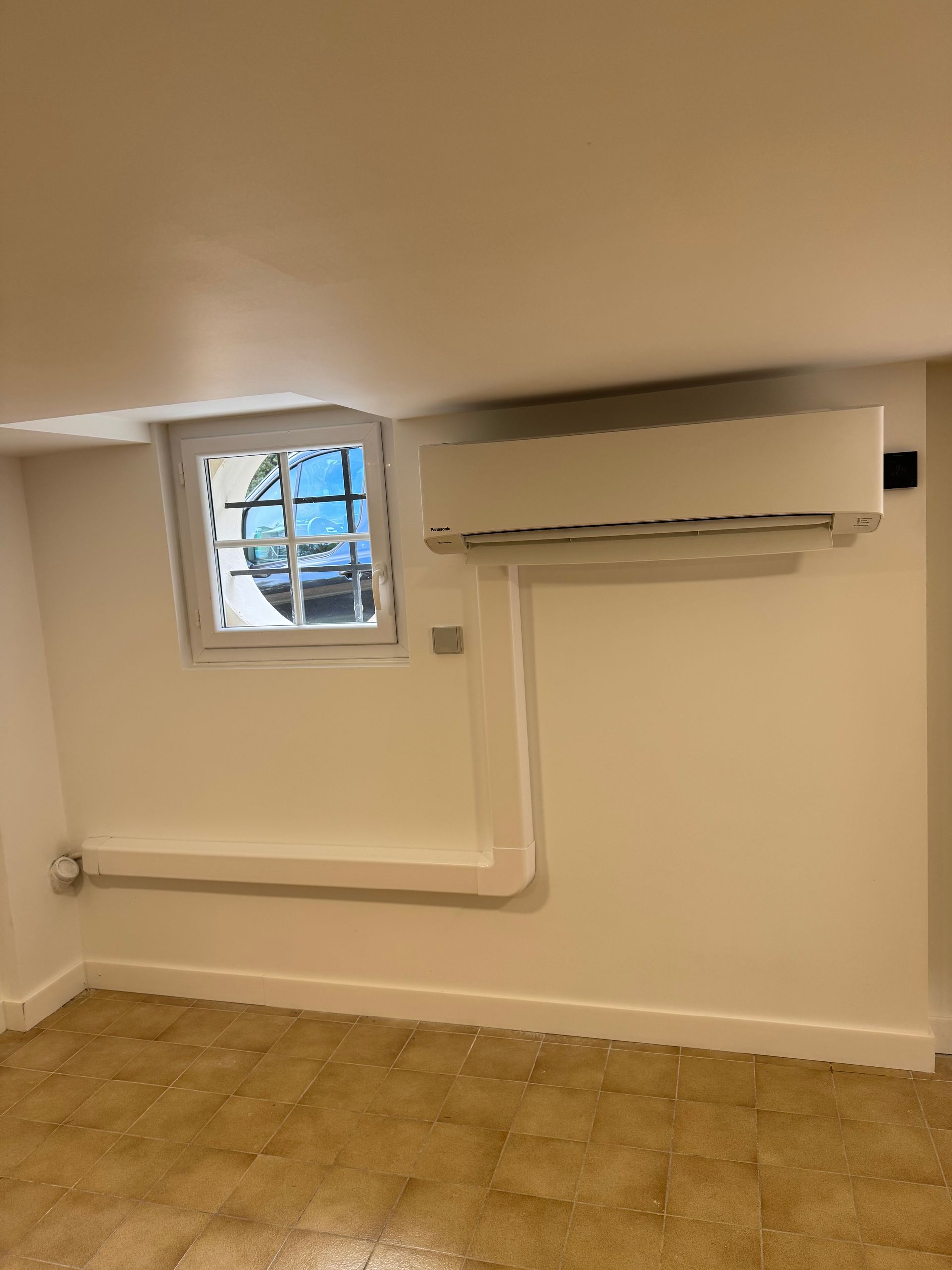 Climatisation sur un mur beige dans une pièce vide