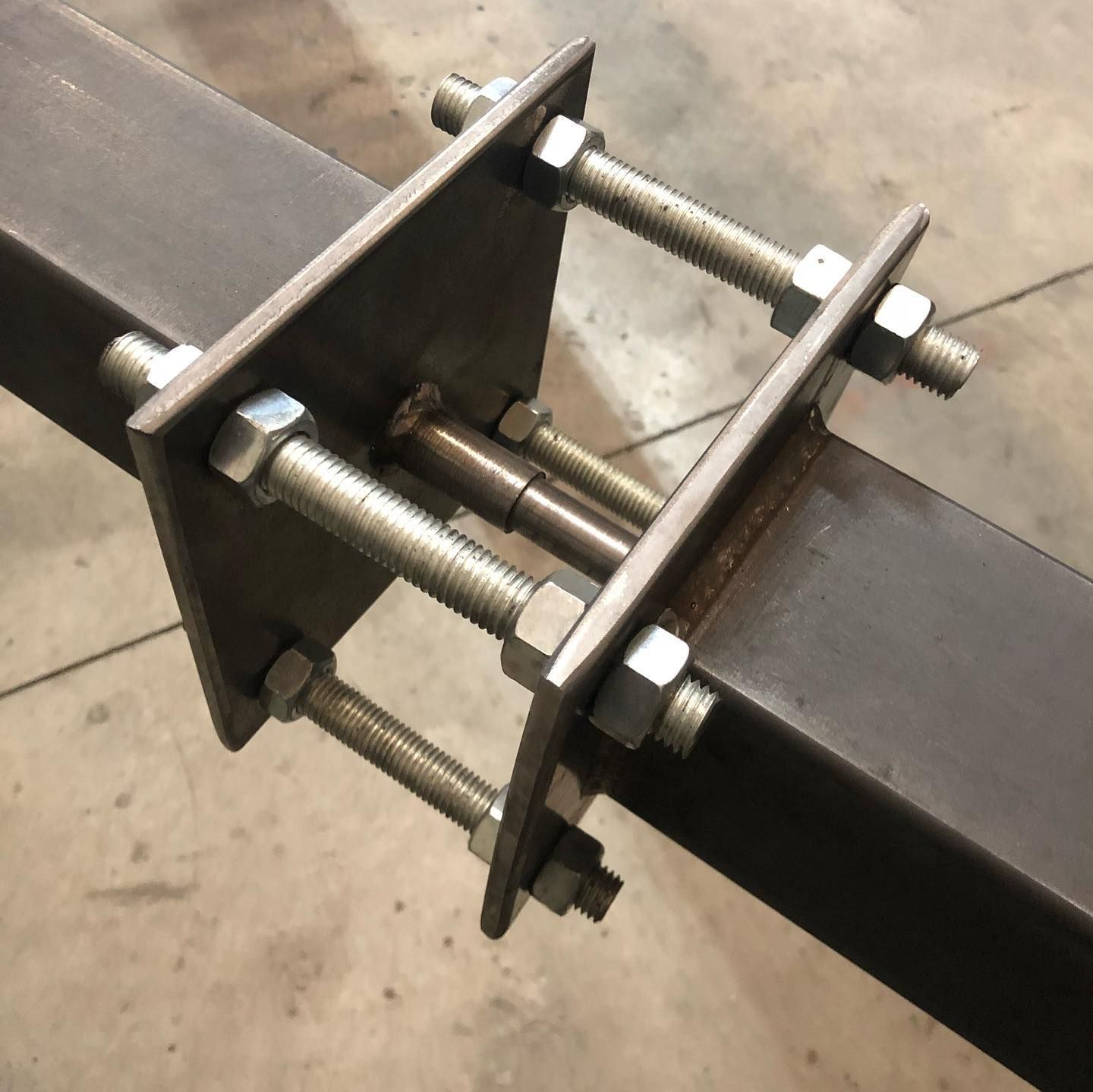 Deux poutres métalliques jointes par des plaques boulonnées.