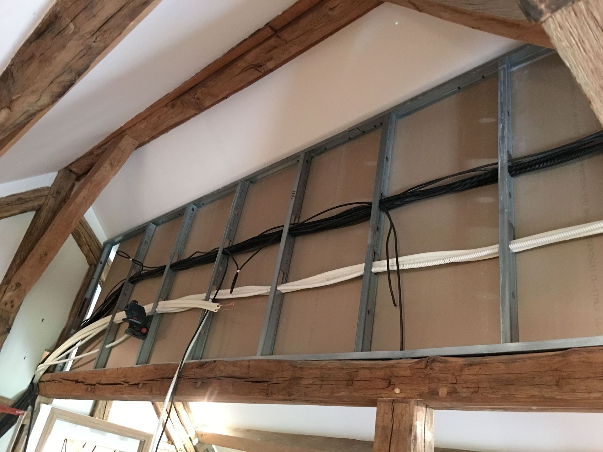 Intérieur avec poutres apparentes, montants métalliques, cloisons sèches et câblage électrique.