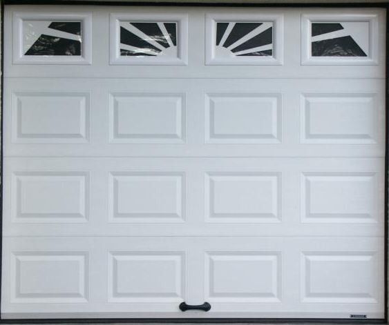 Porte de garage blanche avec quatre vitres en forme de soleil en partie supérieure.