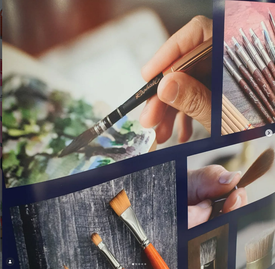 Gros plan sur une main tenant un pinceau au-dessus d'une palette, entourée d'autres pinceaux de tailles et de formes variées.