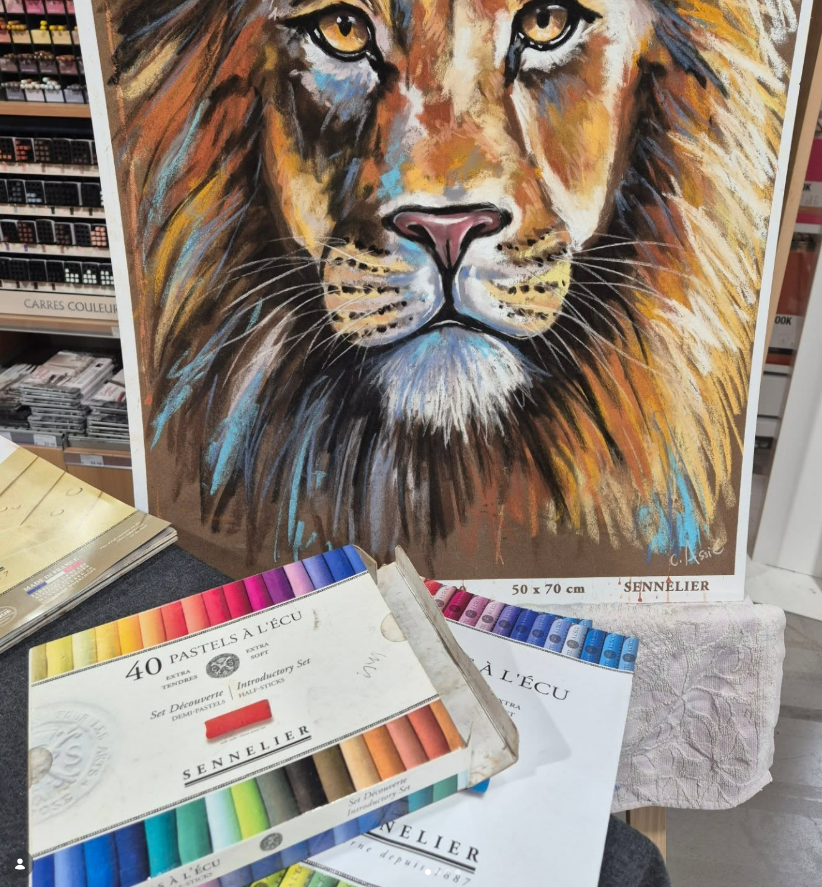 Dessin de lion au pastel avec boîte de pastel ouverte ; œuvre exposée.