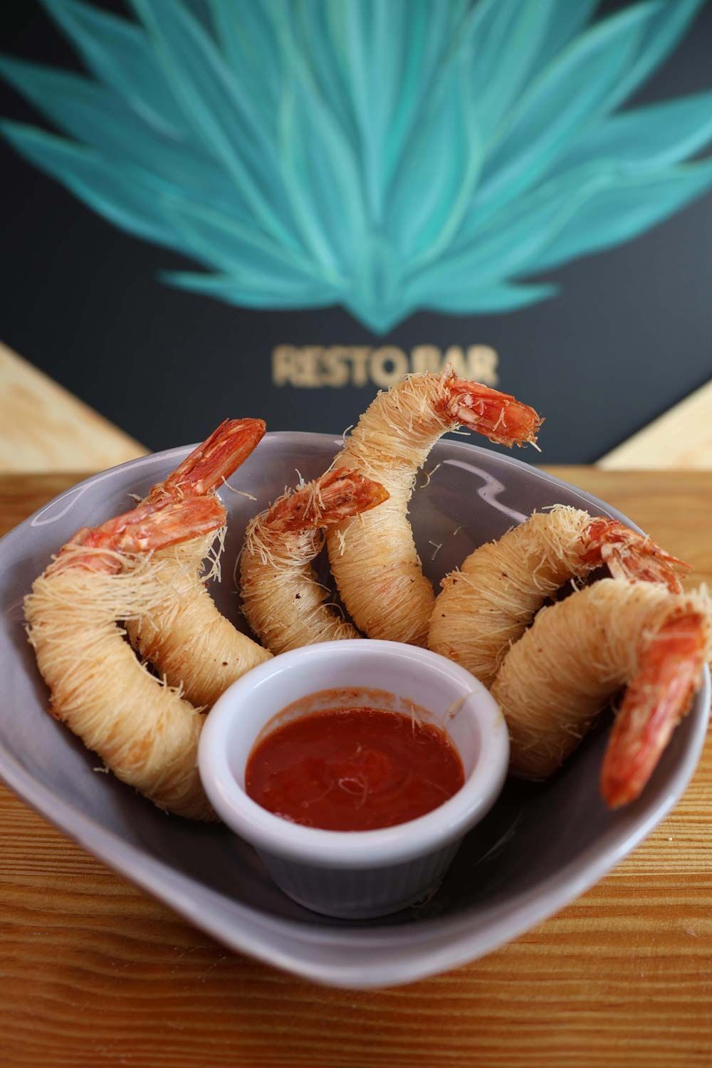 Un tazón de camarones fritos con salsa para mojar