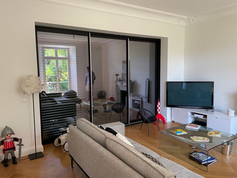 Photographie d'un salon avec une porte-fenêtre aux contours en acier
