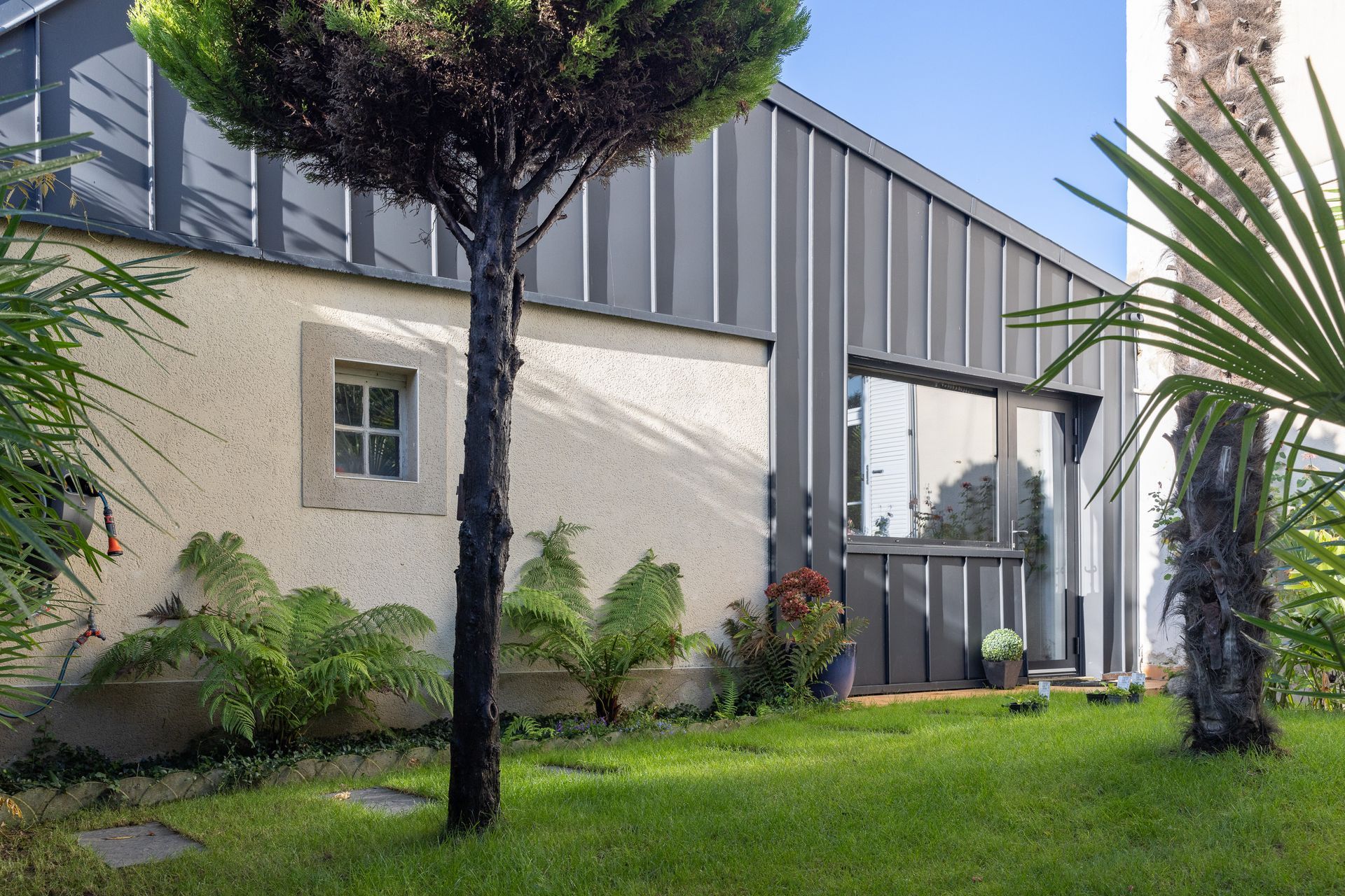 Extérieur d'une maison avec baie vitrée et bardage métallique