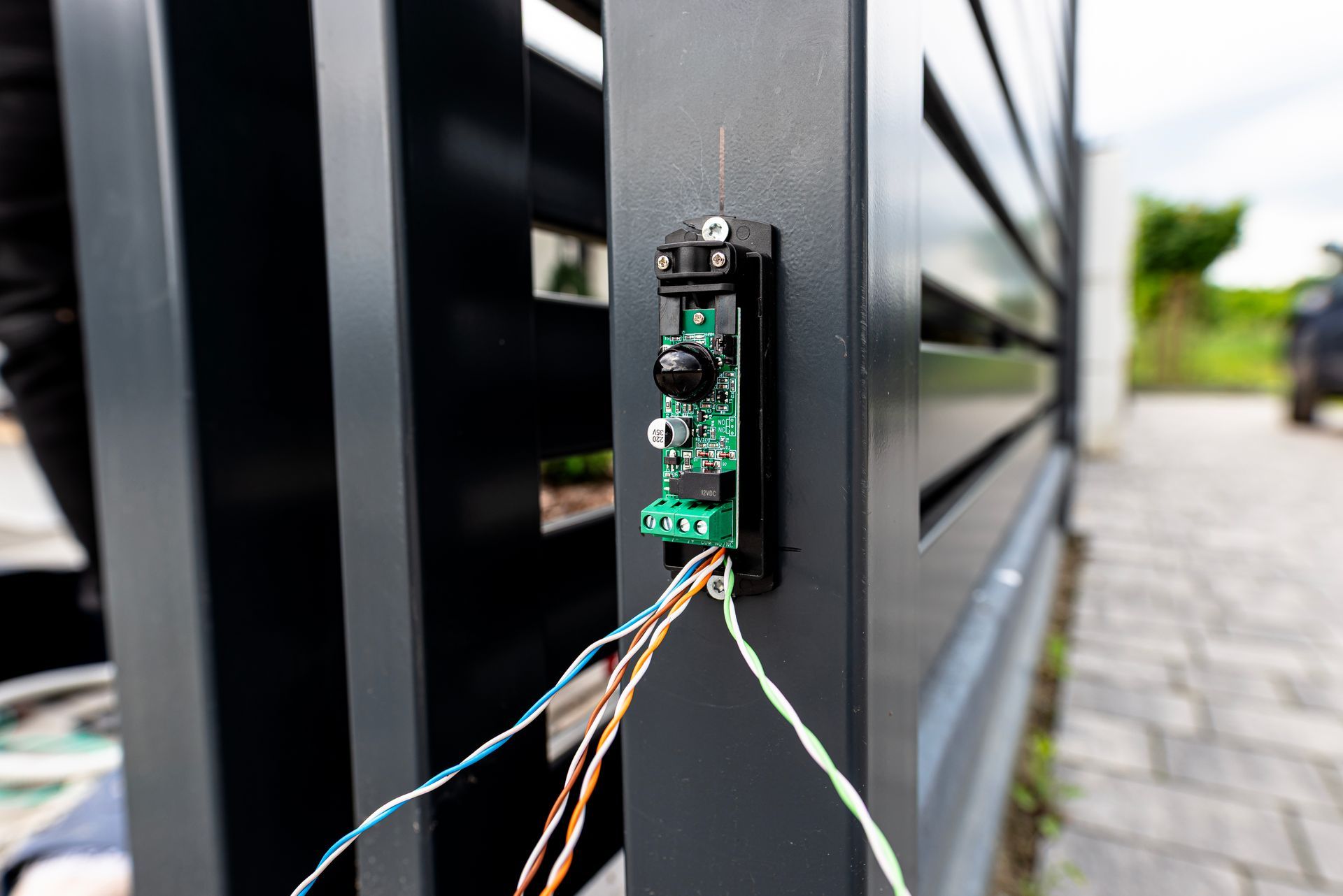 Gros plan d’un petit circuit imprimé fixé sur un support noir, avec des fils raccordés, à l’extérieur