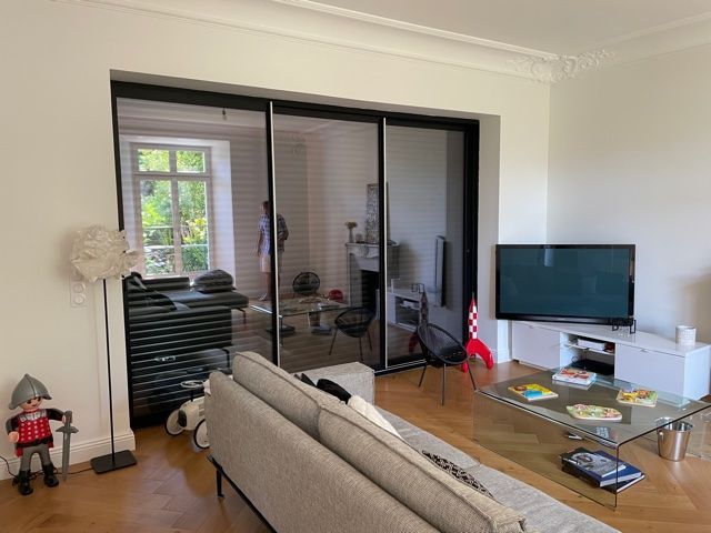 Photographie de l'intérieur d'un salon d'un particulier avec un focus sur les portes-fenêtres