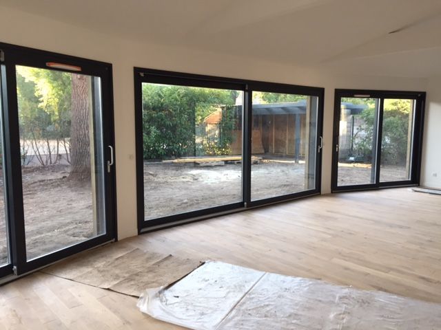 Grandes portes-fenêtres lumineuses dans un grand salon vide