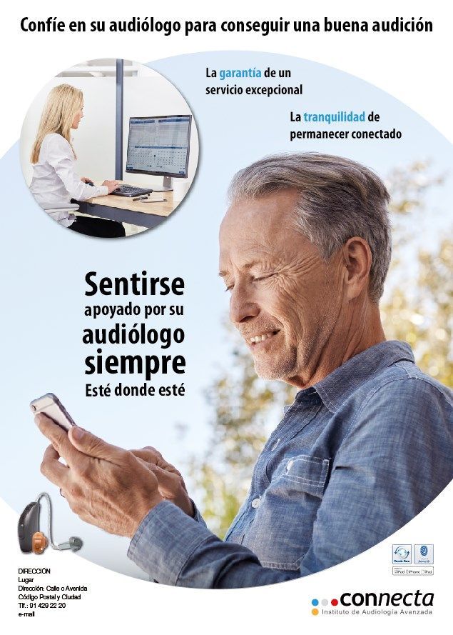 Un hombre mira un teléfono celular mientras una mujer está sentada en un escritorio.