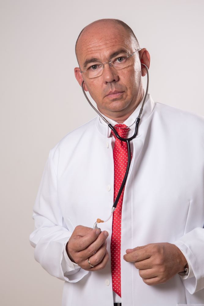 una persona con un fonendoscopio y bata  medica