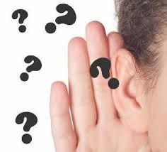 Una persona se lleva la mano a la oreja con signos de interrogación alrededor.