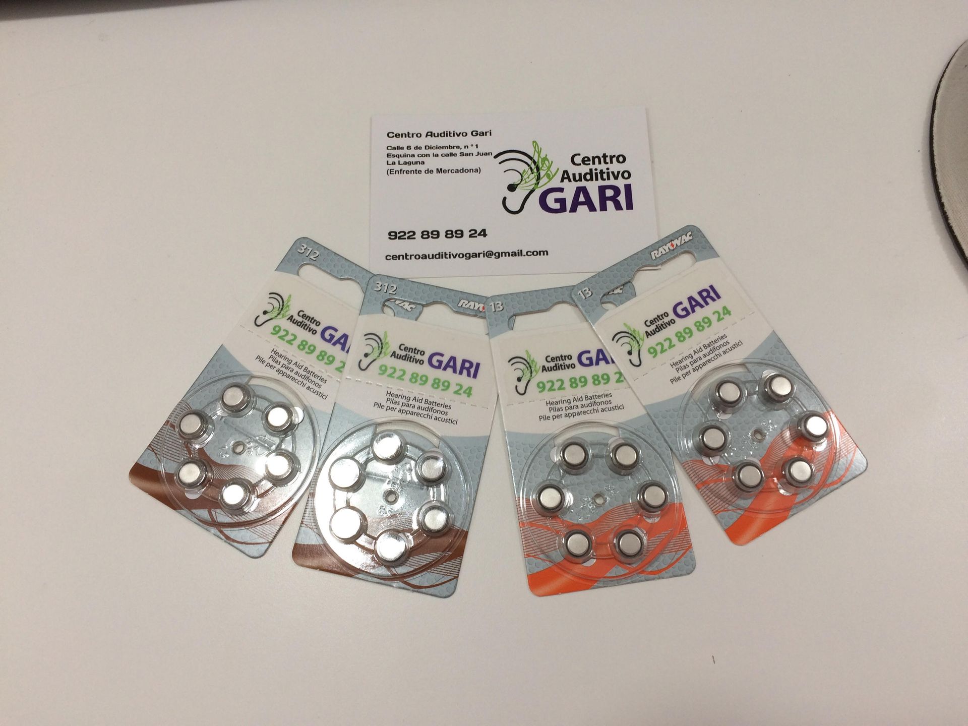 Hay cuatro paquetes de pilas para audífonos sobre una mesa.