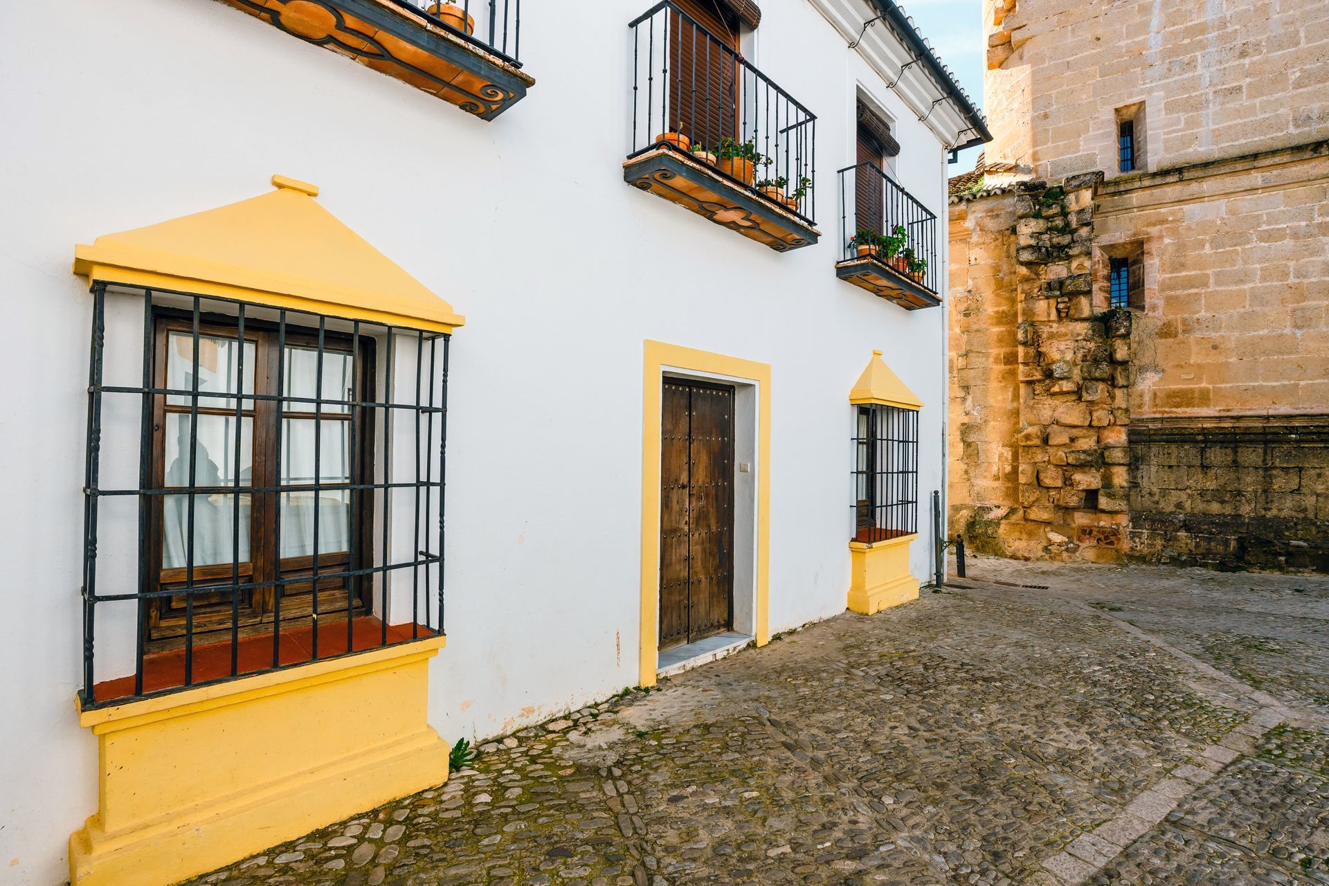 Una casa moderna con balcón y barandilla de cristal.