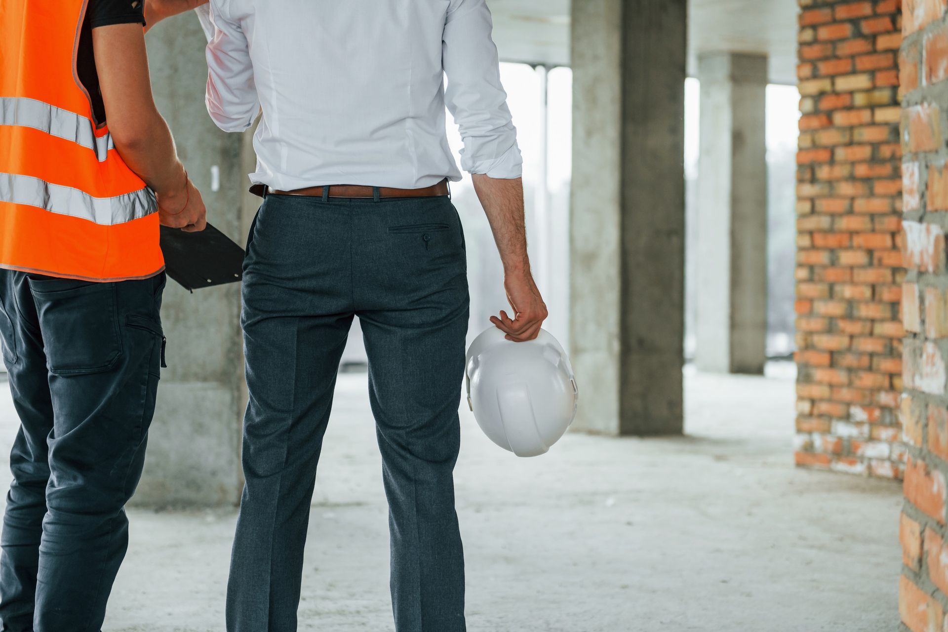 Dos trabajadores de la construcción caminan por un edificio en construcción.