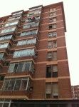Un edificio alto de ladrillo con muchas ventanas y balcones.