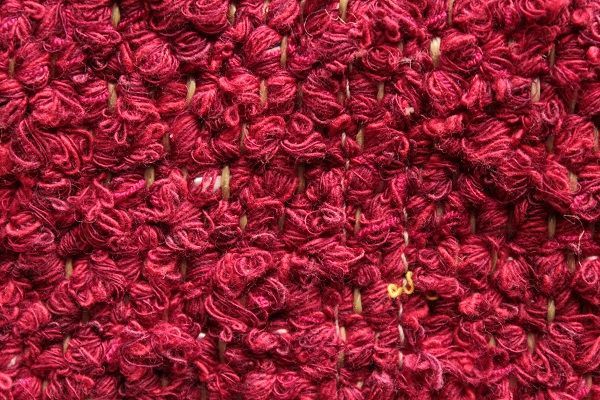 Eine Nahaufnahme eines roten Teppichs mit Strickmuster.