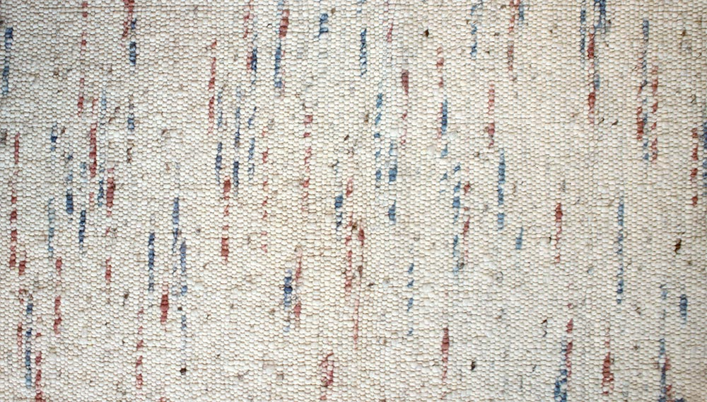 Eine Nahaufnahme eines weißen Teppichs mit roten, blauen und weißen Streifen.