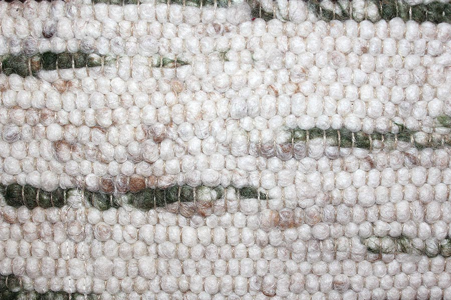 Eine Nahaufnahme eines weiß-grünen Teppichs mit Streifenmuster.