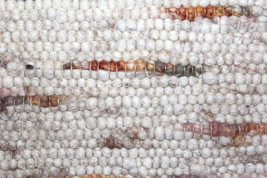 Eine Nahaufnahme eines weißen Teppichs mit einem bunten Muster.