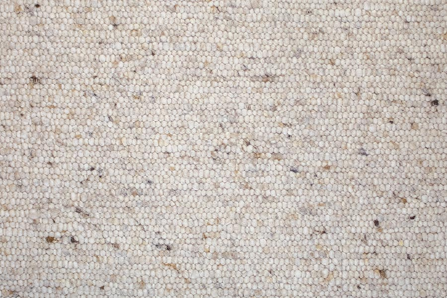 Eine Nahaufnahme eines weißen Teppichs mit Mosaikmuster.