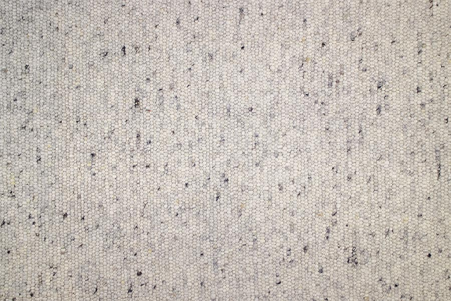 Eine Nahaufnahme eines weißen Teppichs mit schwarzen Flecken.