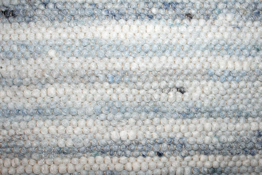 Eine Nahaufnahme eines blau-weiß gestreiften Teppichs.