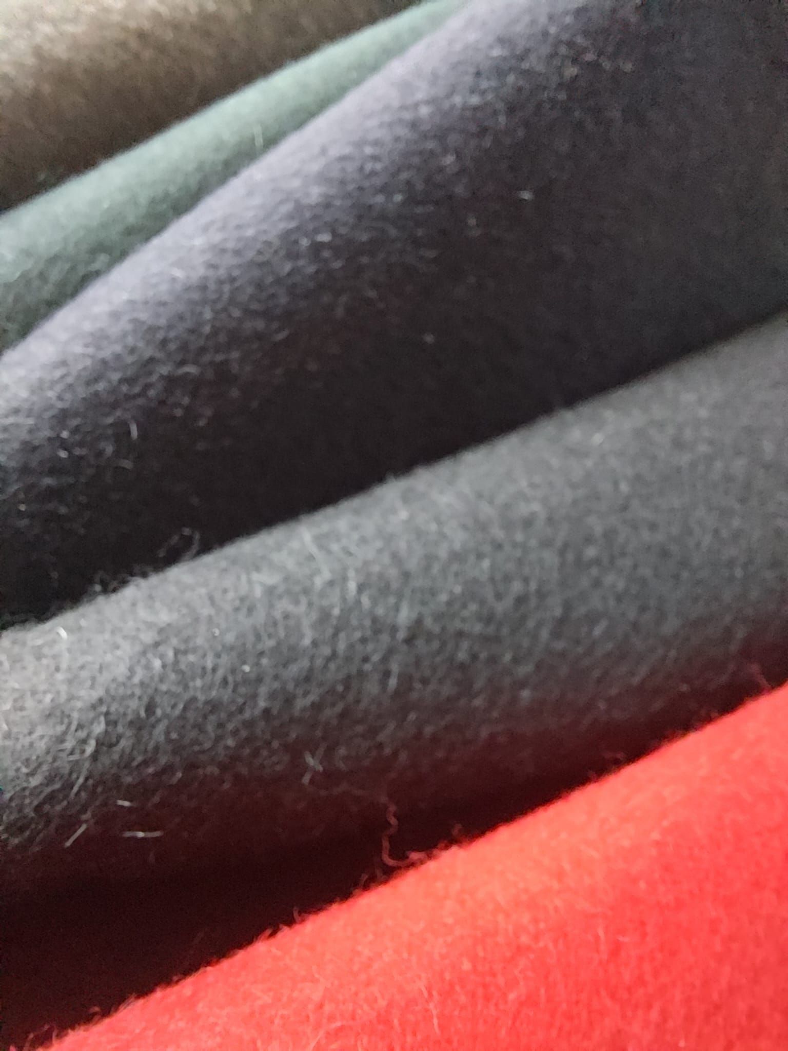 Eine Nahaufnahme eines Bündels verschiedenfarbiger Stoffe, die übereinander gestapelt sind.