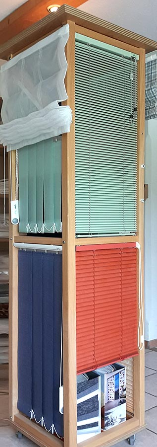 Eine hölzerne Vitrine voller Jalousien unterschiedlicher Art.