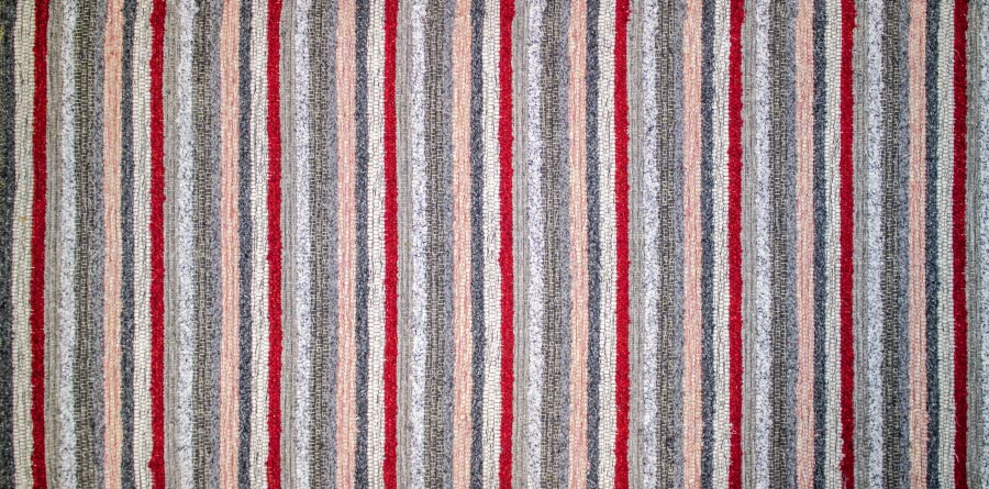 Eine Nahaufnahme eines gestreiften Teppichs mit roten und grauen Streifen.