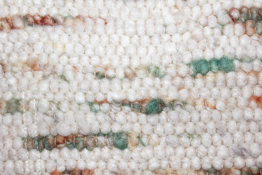 Eine Nahaufnahme eines weißen Teppichs mit Streifenmuster.