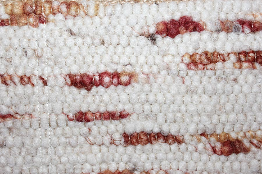 Eine Nahaufnahme eines weiß-roten Teppichs mit Streifenmuster.