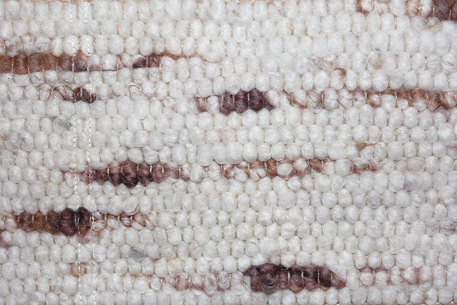Eine Nahaufnahme eines weißen Teppichs mit braunen Streifen.