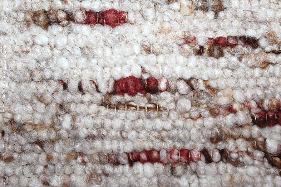 Eine Nahaufnahme eines weißen Teppichs mit roten Perlen darauf.