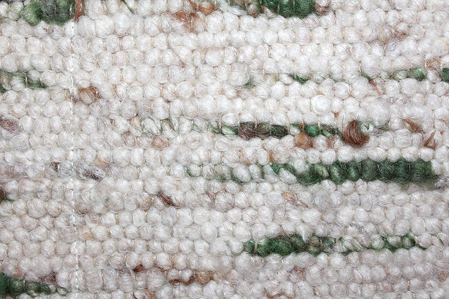 Eine Nahaufnahme eines weißen Teppichs mit grünen Streifen.