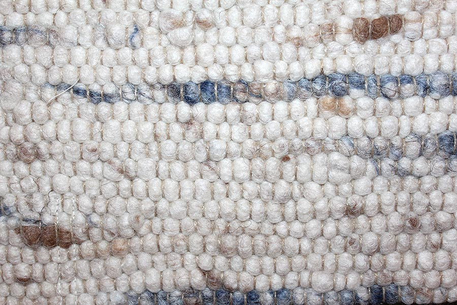 Eine Nahaufnahme eines weißen Teppichs mit blauen und braunen Streifen.