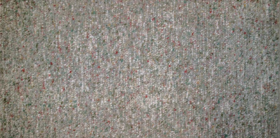 Eine Nahaufnahme eines Teppichs mit vielen kleinen Punkten darauf.
