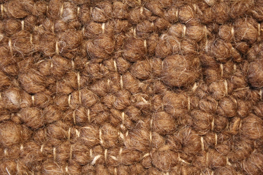 Eine Nahaufnahme der Struktur eines braunen Teppichs.