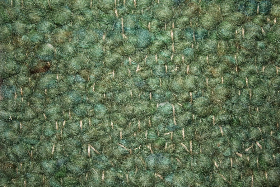 Eine Nahaufnahme der Struktur eines grünen Teppichs.