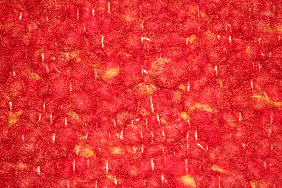 Eine Nahaufnahme von einem roten Teppich mit gelben Flecken