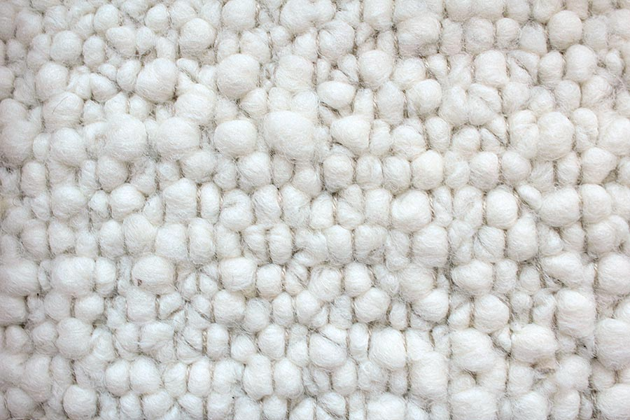 Eine Nahaufnahme eines weißen Teppichs mit Strickmuster.