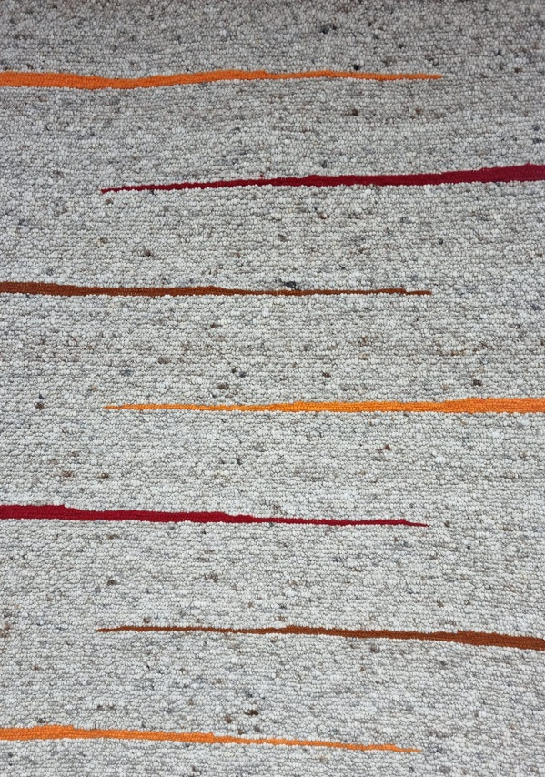 Eine Nahaufnahme eines Teppichs mit roten und orangefarbenen Streifen.