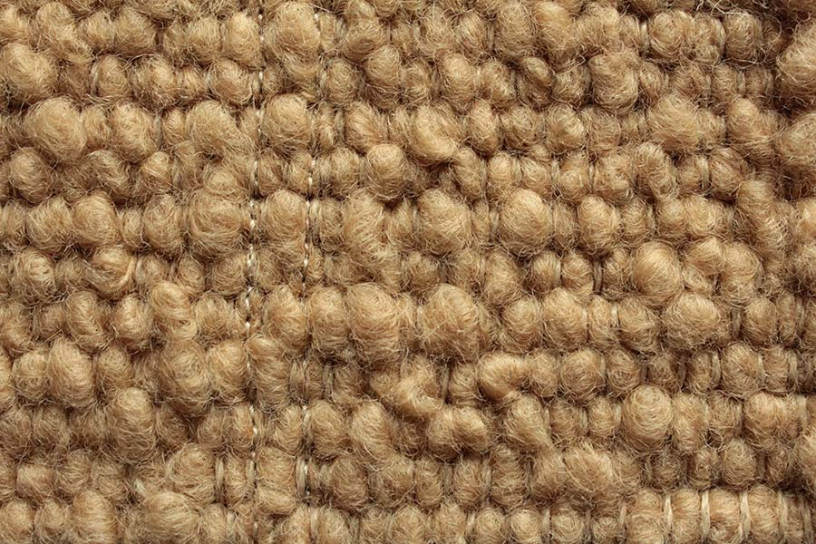 Eine Nahaufnahme eines braunen Teppichs mit Strickmuster.