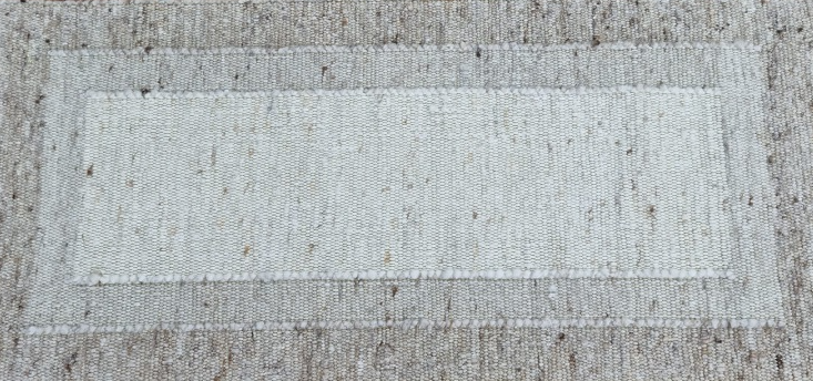 Auf einem braunen Teppich liegt ein weißes Rechteck.