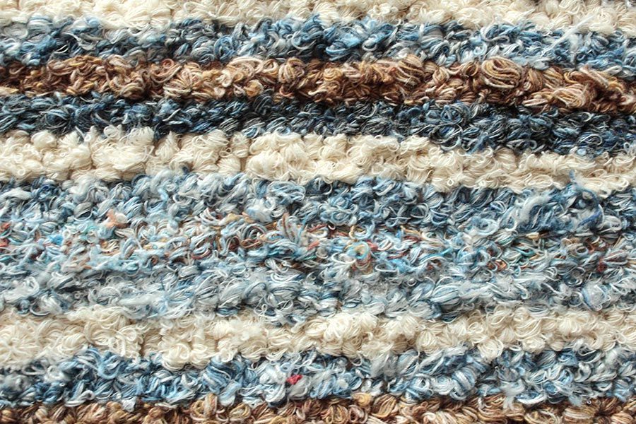 Eine Nahaufnahme einer gestrickten Decke mit Streifenmuster.