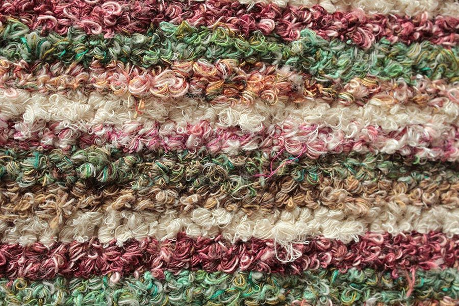 Eine Nahaufnahme einer gestrickten Decke mit Streifenmuster.