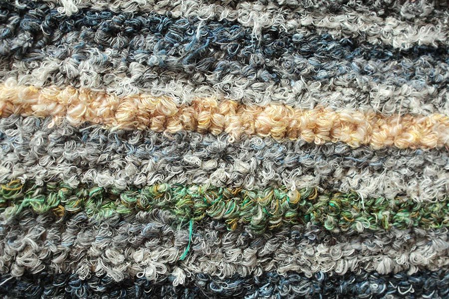 Eine Nahaufnahme einer gestrickten Decke mit Streifenmuster.