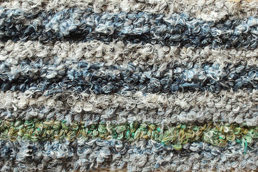 Eine Nahaufnahme einer gestrickten Decke mit Streifenmuster.