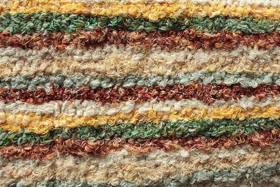 Eine Nahaufnahme eines bunt gestreiften Teppichs.