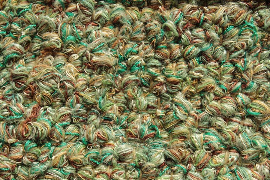 Eine Nahaufnahme eines Stapels aus grünem und braunem Garn.