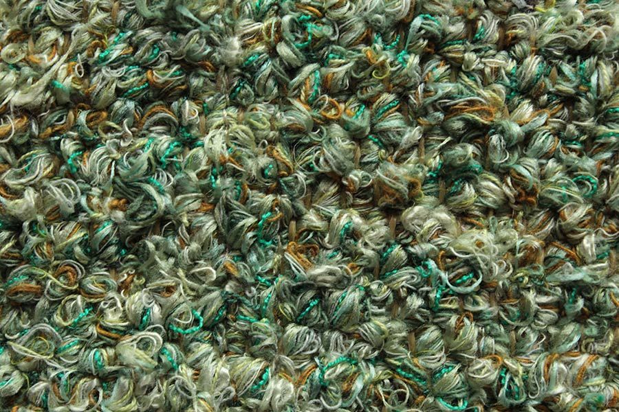 Eine Nahaufnahme eines Stapels aus grünem und braunem Garn.